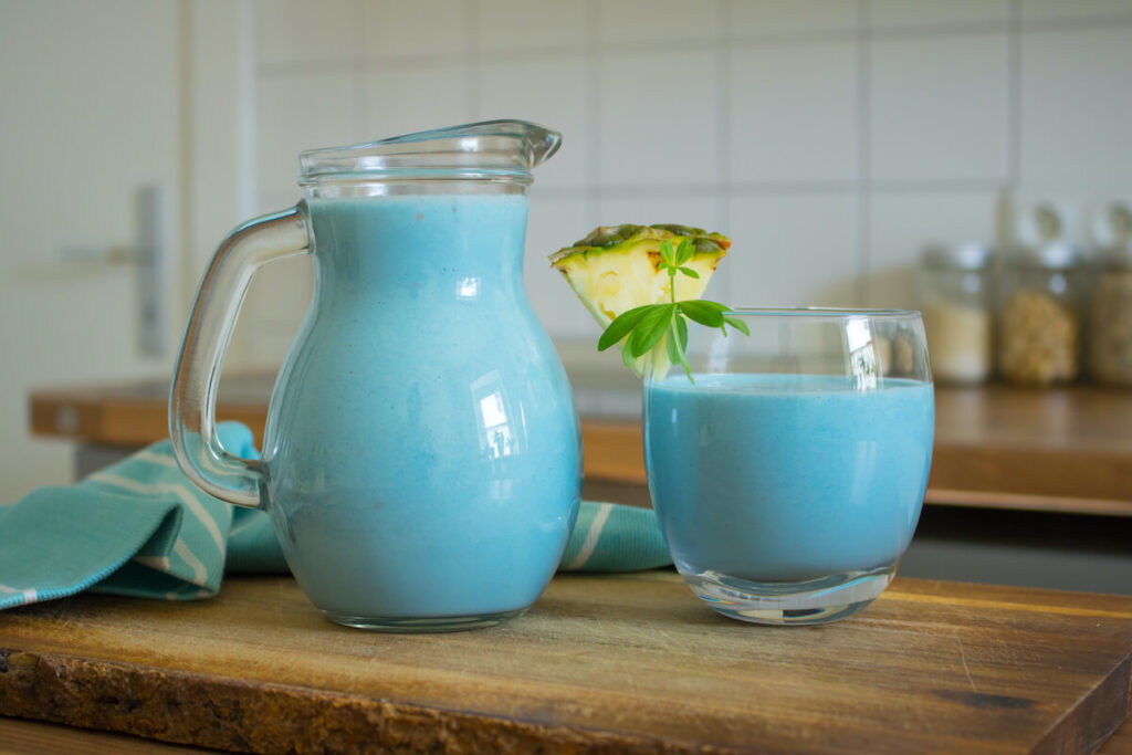 Smoothie de espirulina azul com abacaxi na mesa de madeira